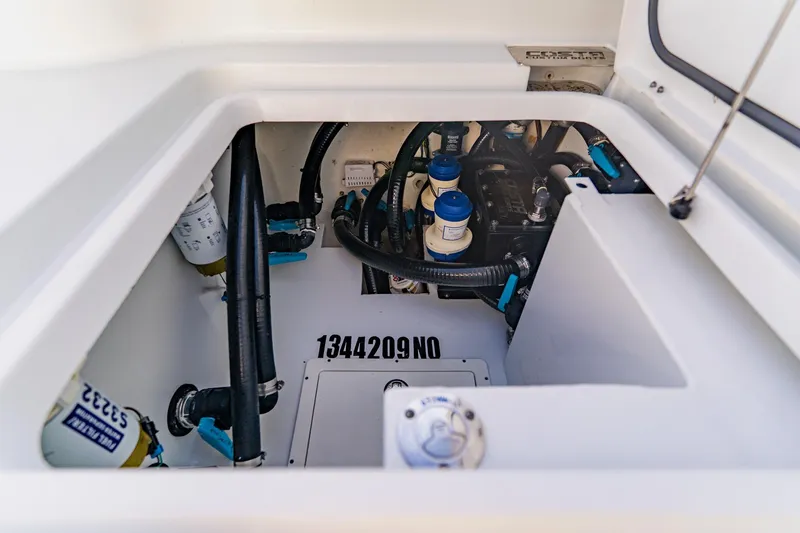 Slide: The Image of Engine compartment of 2024 Costa Custom Boats 34SV, showcasing mechanical components and wiring. - 55