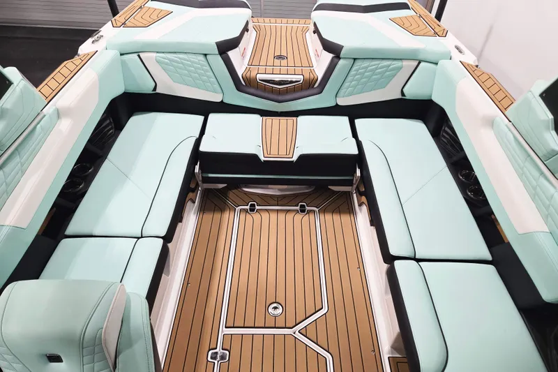 Slide: The Image of 2024 Nautique Super Air Nautique G23 interior with mint green seating and teak flooring. - 12