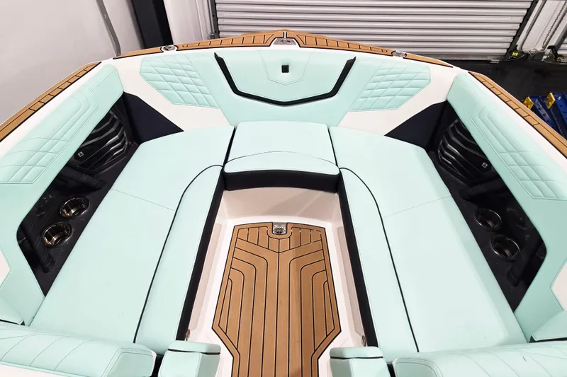 Slide: The Image of 2024 Nautique Super Air Nautique G23 boat interior with mint green seating and teak flooring. - 14