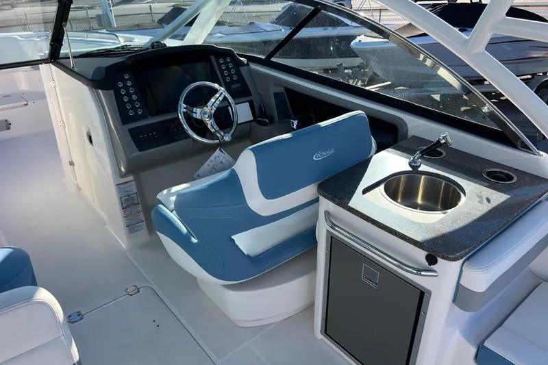 Slide: The Image of 2026 Robalo R317 Dual Console interior with helm, sink, and seating. - 10