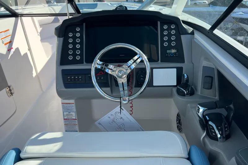 Slide: The Image of 2026 Robalo R317 Dual Console boat dashboard with steering wheel and controls. - 11