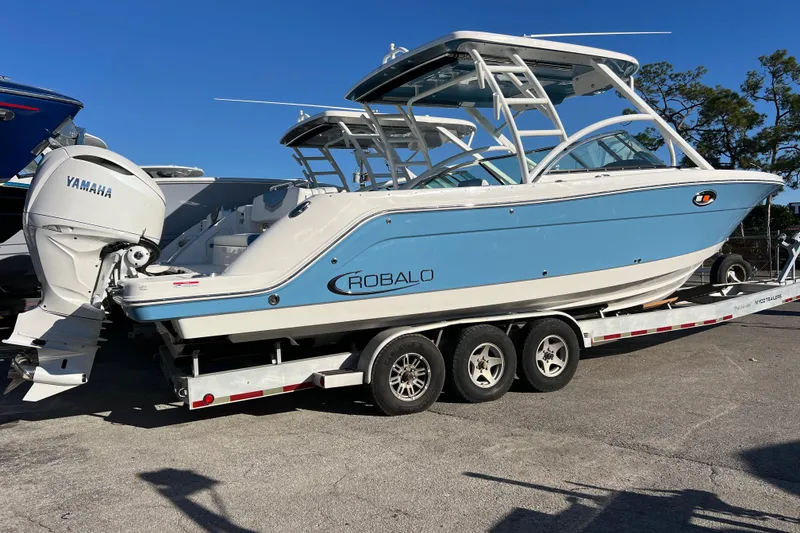 Slide: The Image of 2026 Robalo R317 Dual Console boat on trailer with Yamaha engine, blue and white design. - 3
