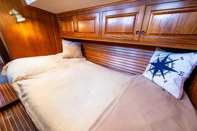 Slide: The Image of Cozy cabin interior of 1974 C&C 61 Ocean Racer with wooden finish and nautical-themed pillow. - 19