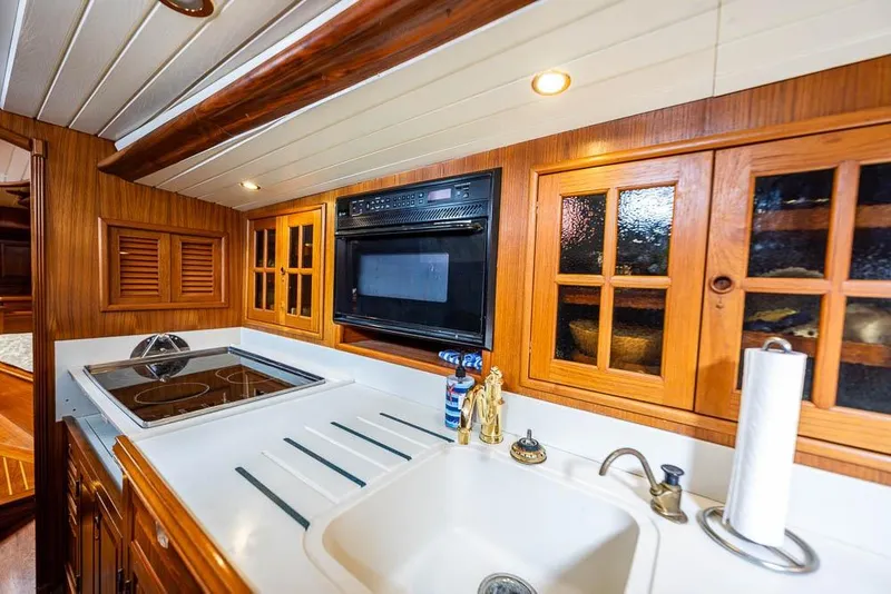 Slide: The Image of 1974 C&C 61 Ocean Racer/Cruiser kitchen with wooden cabinets and modern appliances. - 33