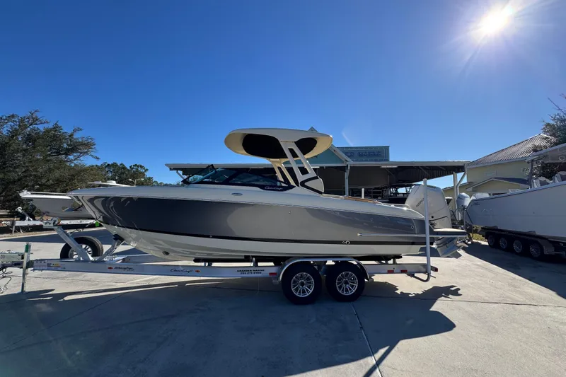 The Image of 2026 Chris-Craft Sportster 28 boat on trailer under clear blue sky. - 1