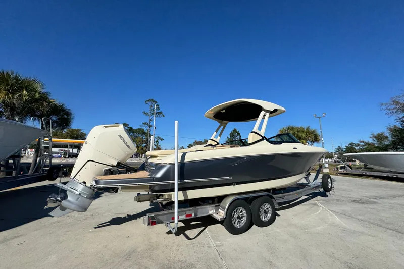 Slide: The Image of 2026 Chris-Craft Sportster 28 boat on trailer under clear blue sky. - 12