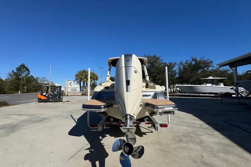Slide: The Image of 2026 Chris-Craft Sportster 28 boat rear view, parked outdoors under clear blue sky. - 15