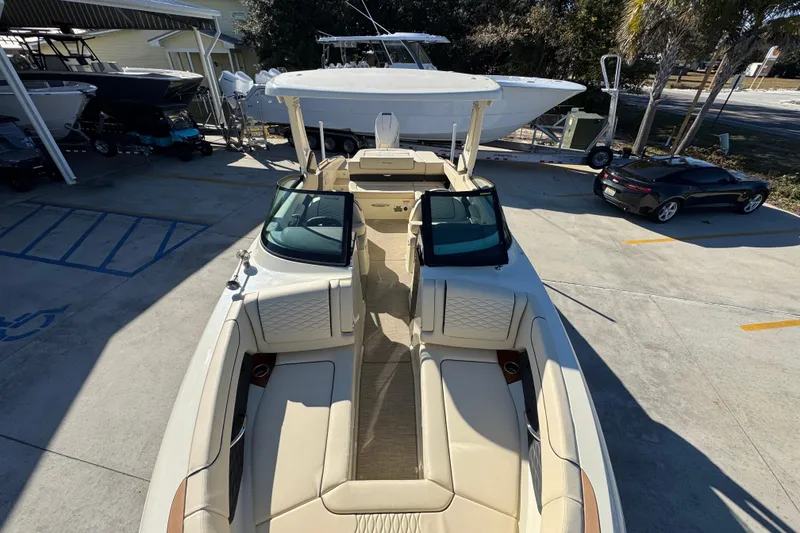 Slide: The Image of 2026 Chris-Craft Sportster 28 boat with luxurious seating, parked outdoors. - 21