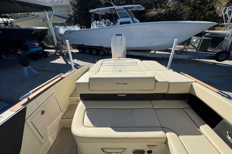 Slide: The Image of 2026 Chris-Craft Sportster 28 boat interior with beige seating, docked near other boats. - 38