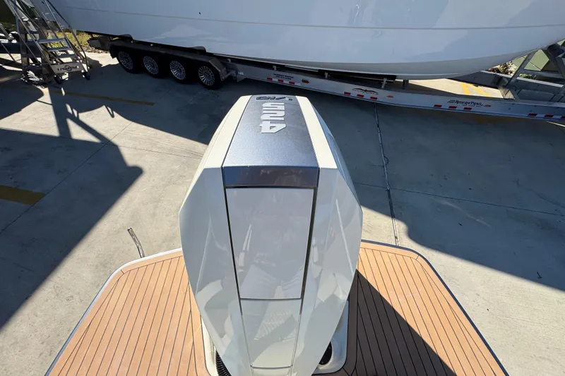 Slide: The Image of 2026 Chris-Craft Sportster 28 outboard engine on wooden deck, trailer in background. - 48