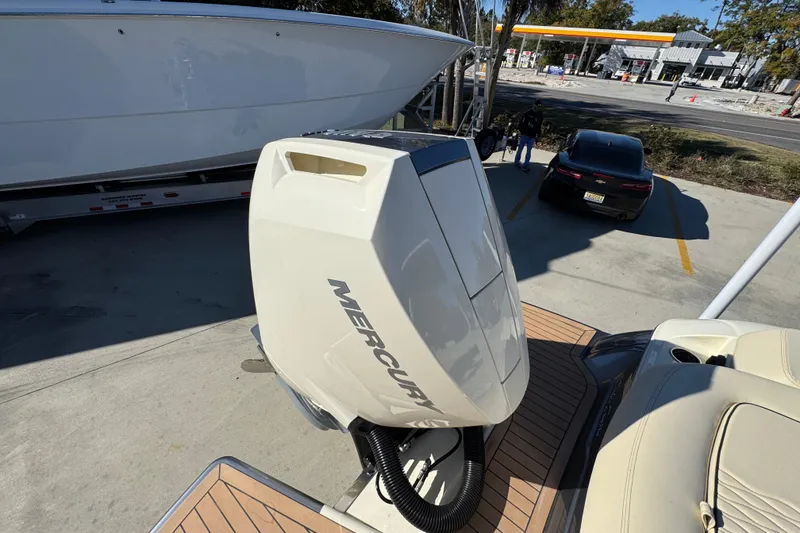 Slide: The Image of 2026 Chris-Craft Sportster 28 with Mercury outboard engine, parked near a gas station. - 49