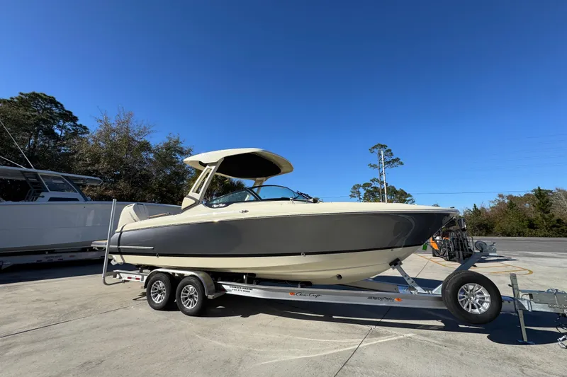 Slide: The Image of 2026 Chris-Craft Sportster 28 boat on trailer under clear blue sky. - 9