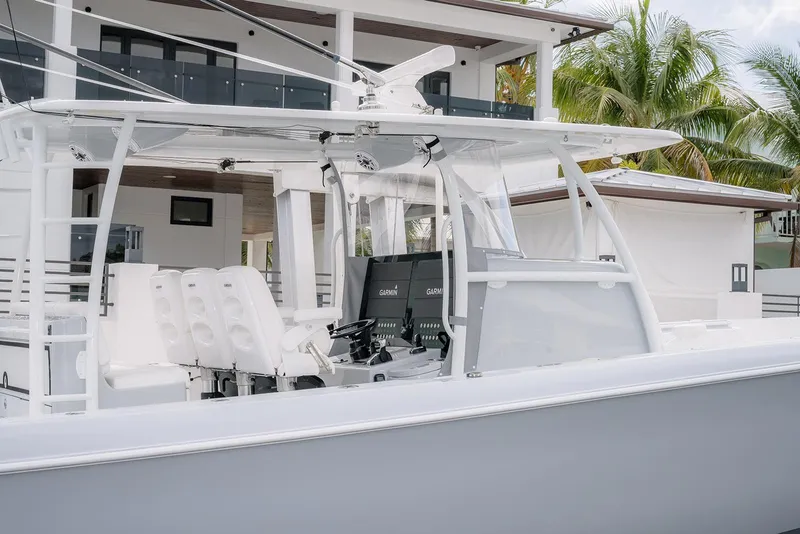 Slide: The Image of 2024 Contender 44 ST boat with modern helm, white seating, and tropical backdrop. - 17