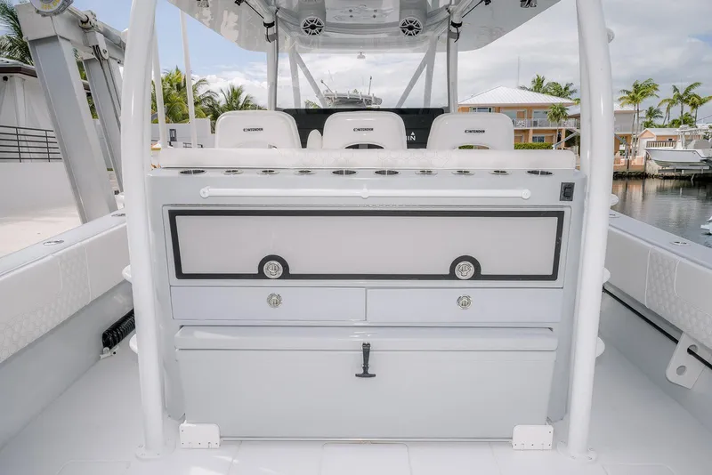 Slide: The Image of 2024 Contender 44 ST boat interior with seating and storage, docked near waterfront homes. - 26