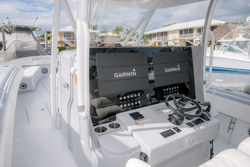 Slide: The Image of 2024 Contender 44 ST boat cockpit with Garmin navigation displays and steering wheel. - 30