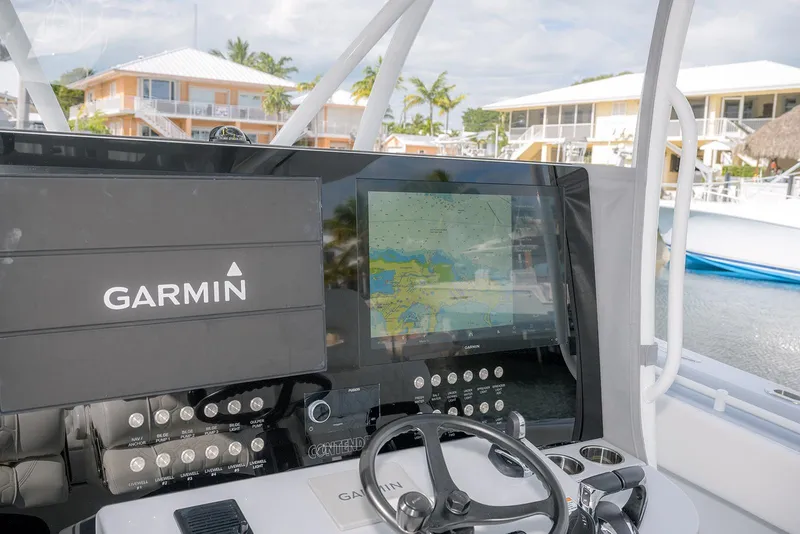 Slide: The Image of 2024 Contender 44 ST boat dashboard with Garmin navigation system and steering wheel. - 35