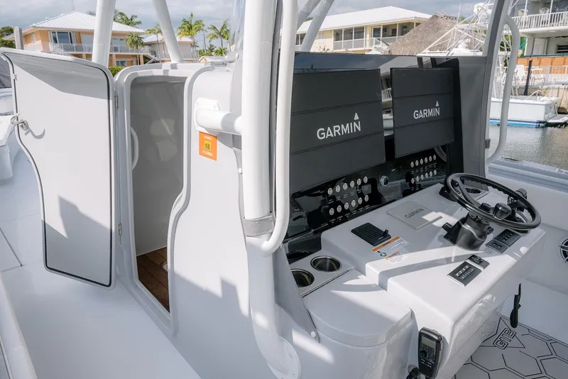Slide: The Image of 2024 Contender 44 ST boat cockpit with Garmin navigation system and open cabin door. - 38