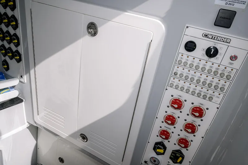Slide: The Image of 2024 Contender 44 ST boat control panel with switches and storage compartment. - 41