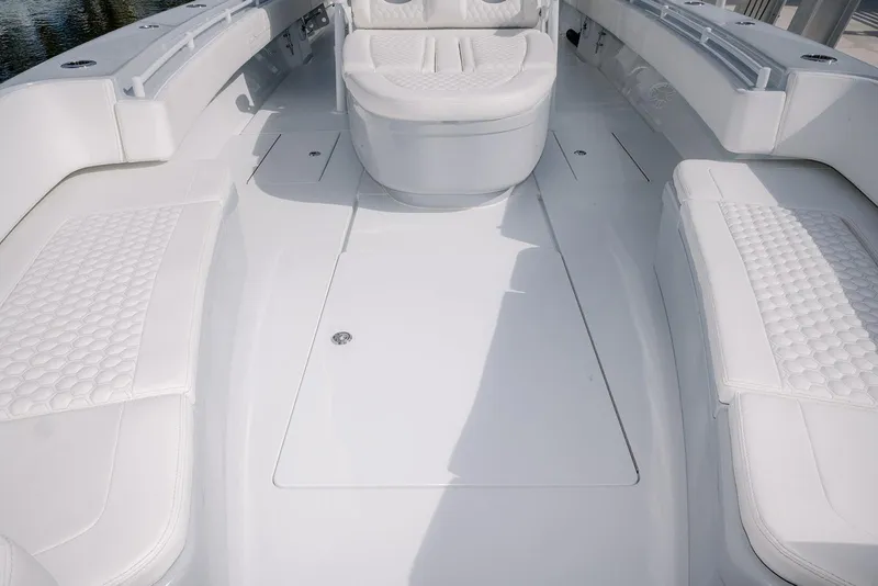 Slide: The Image of 2024 Contender 44 ST boat interior with white cushioned seating and sleek design. - 49
