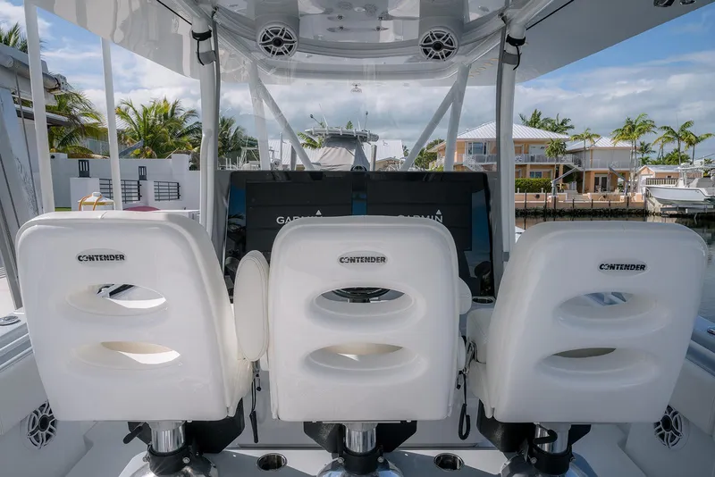 Slide: The Image of 2024 Contender 44 ST boat interior with three white seats and waterfront view. - 66