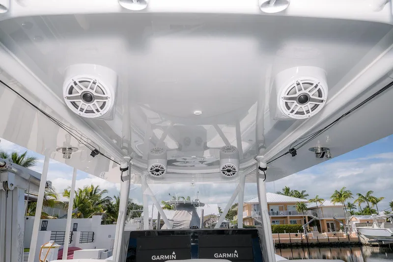 Slide: The Image of 2024 Contender 44 ST boat with speakers and Garmin equipment, docked in a sunny marina. - 67