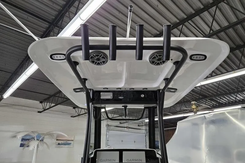 Slide: The Image of 2026 Sea Hunt Ultra 265 SE boat with T-top and rod holders in a showroom. - 11