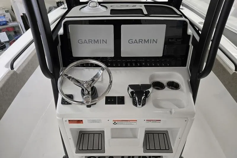 Slide: The Image of 2026 Sea Hunt Ultra 265 SE boat console with dual Garmin displays and steering wheel. - 4
