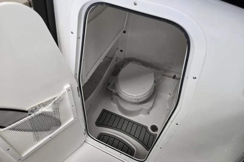 Slide: The Image of 2026 Sea Hunt Ultra 265 SE boat interior with compact marine toilet. - 7