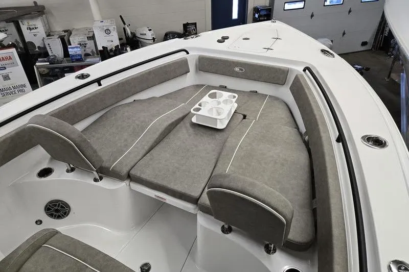 Slide: The Image of 2026 Sea Hunt Ultra 265 SE boat interior with cushioned seating and cup holders. - 9