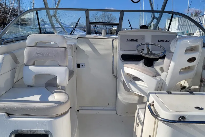 Slide: The Image of 2008 Boston Whaler 305 Conquest interior with helm and seating, featuring Simrad electronics. - 4