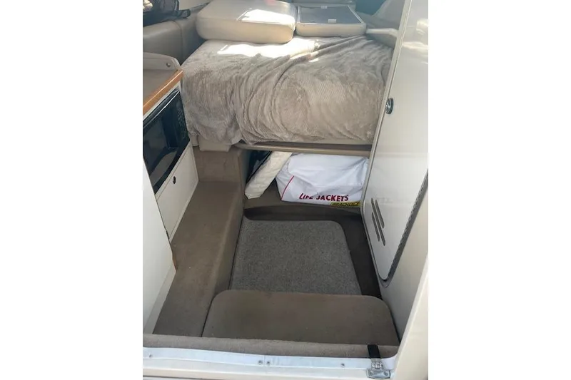 The Image of Interior cabin of 1998 Chaparral 2835 SS boat with bed and life jackets. - 1