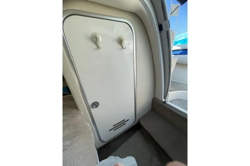 Slide: The Image of Interior cabin door of a 1998 Chaparral 2835 SS boat, featuring hooks and a vent. - 17