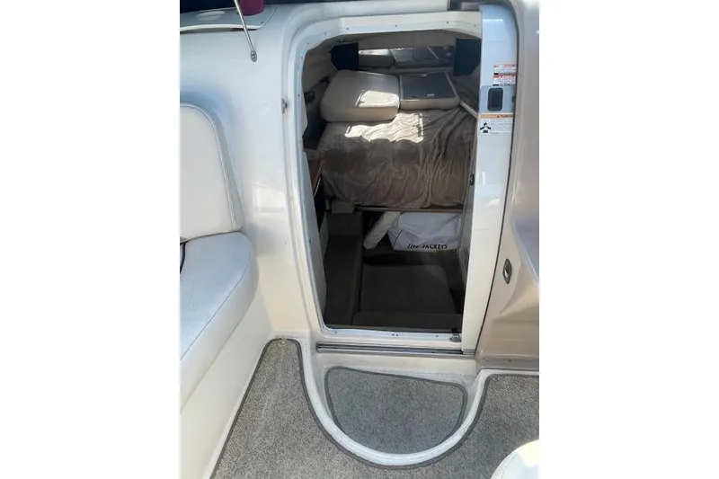 Slide: The Image of Interior cabin view of a 1998 Chaparral 2835 SS boat, featuring seating and bedding. - 20
