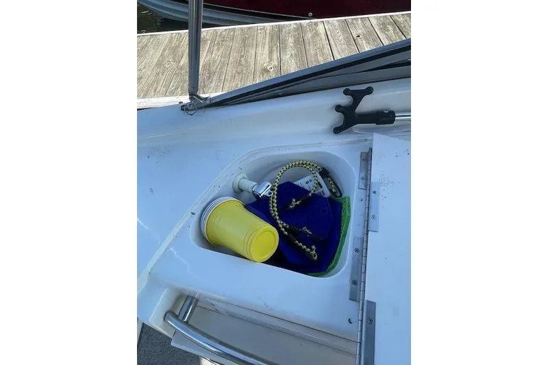 Slide: The Image of Storage compartment on a 1998 Chaparral 2835 SS boat with cleaning supplies and rope. - 24