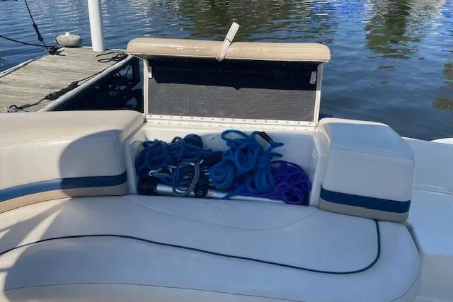 Slide: The Image of 1998 Chaparral 2835 SS boat with open storage compartment, docked by the water. - 31