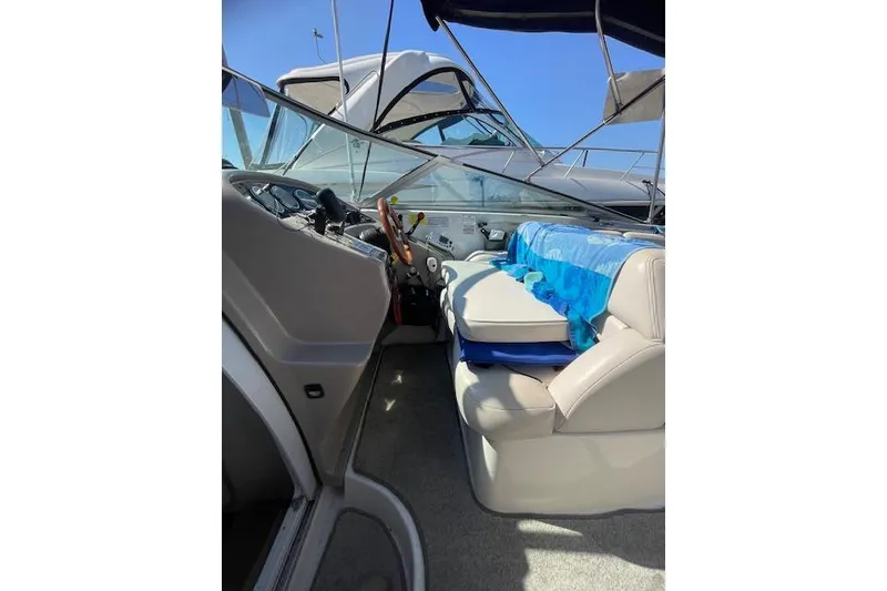 Slide: The Image of 1998 Chaparral 2835 SS boat interior with seating and dashboard under blue sky. - 33