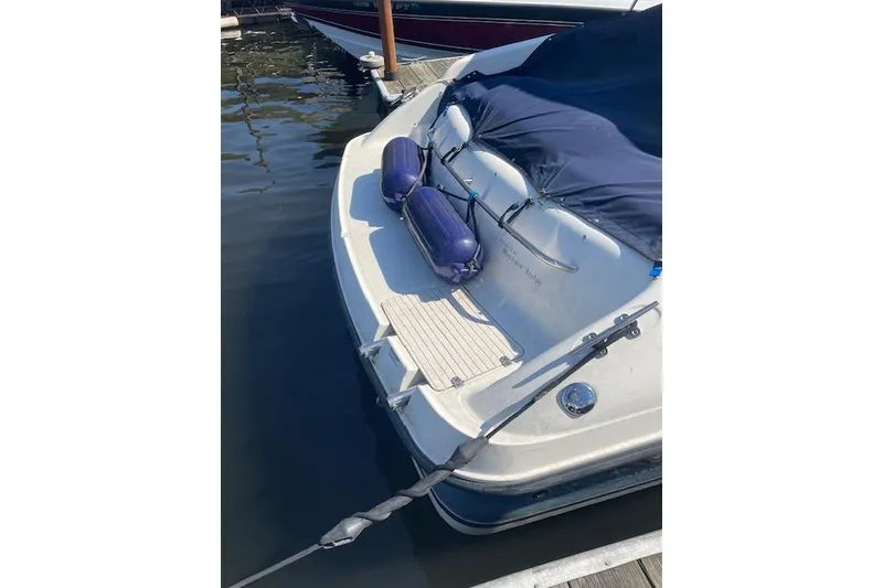 Slide: The Image of 1998 Chaparral 2835 SS boat docked, covered with blue tarp, and equipped with fenders. - 40
