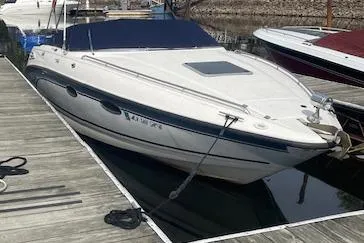Slide: The Image of 1998 Chaparral 2835 SS boat docked at a marina, featuring sleek white design. - 47