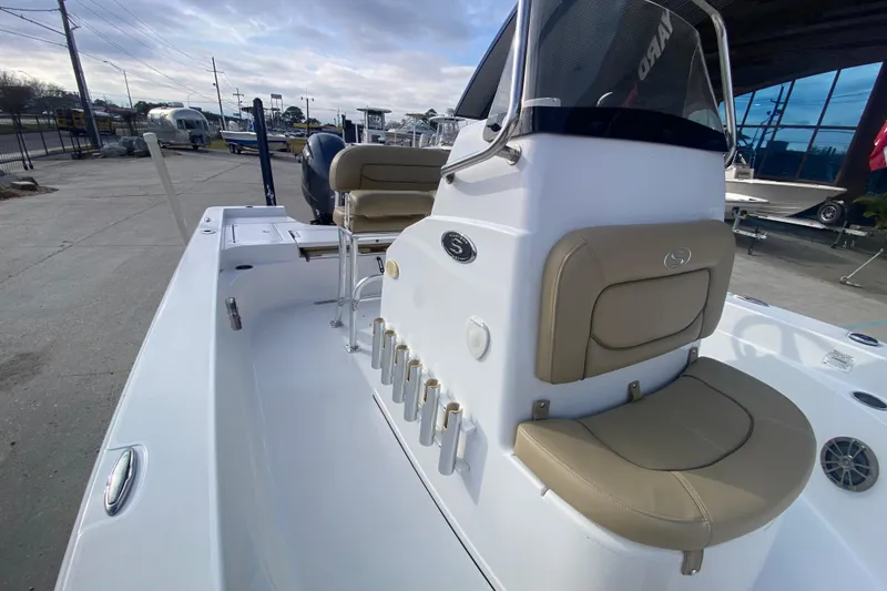 Slide: The Image of 2015 Sportsman Masters 227 Bay Boat with beige seating and rod holders, docked outdoors. - 14