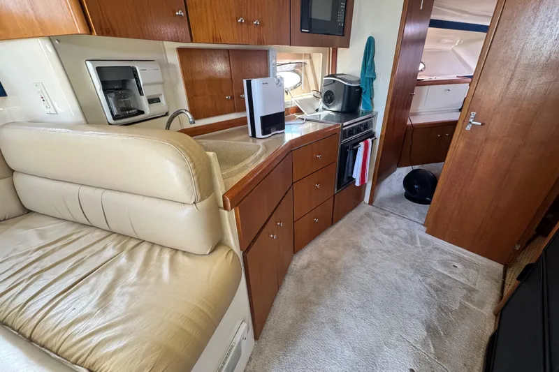 Slide: The Image of 1997 Carver 350 Mariner interior with kitchen, seating, and wooden cabinetry. - 11