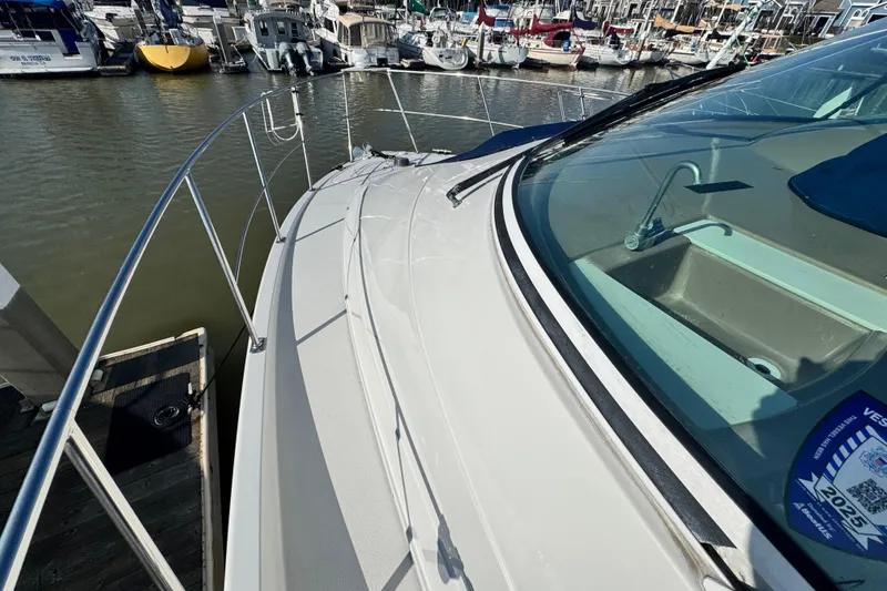 Slide: The Image of 1997 Carver 350 Mariner yacht docked at marina, showcasing sleek design and spacious deck. - 19