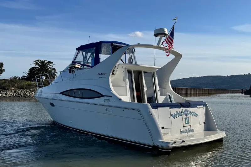 Slide: The Image of 1997 Carver 350 Mariner yacht on water, rear view with American flag. - 4