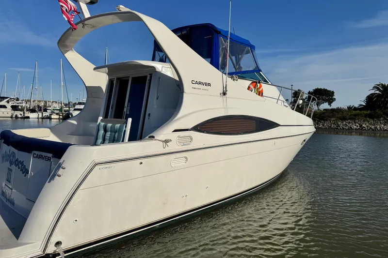 Slide: The Image of 1997 Carver 350 Mariner yacht docked in a marina under clear blue skies. - 5