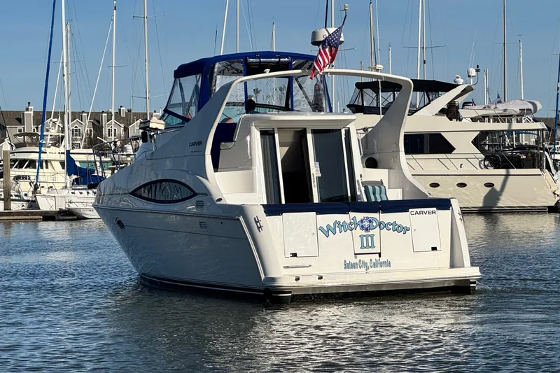 Slide: The Image of 1997 Carver 350 Mariner yacht docked in a marina, featuring "Witch Doctor III" name. - 7