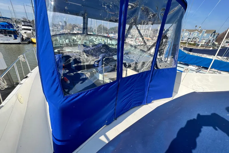 Slide: The Image of 1997 Carver 350 Mariner with blue canopy docked at marina. - 16