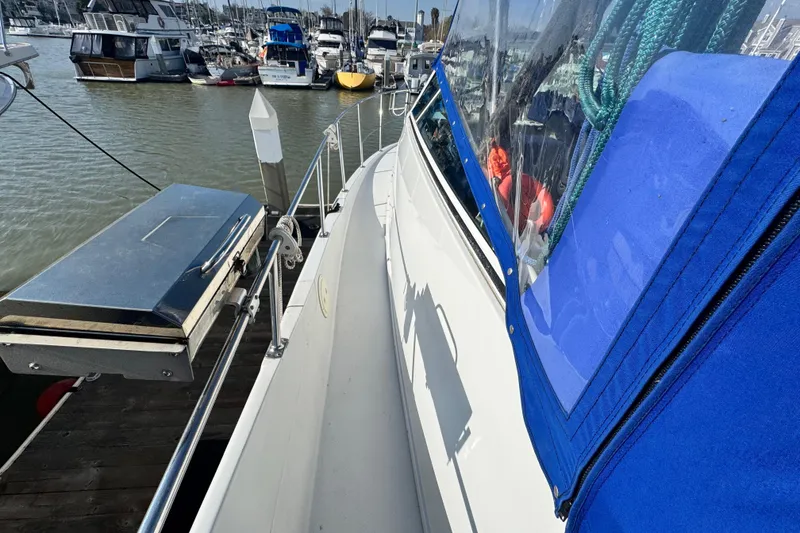Slide: The Image of 1997 Carver 350 Mariner docked, featuring blue canopy and marina view. - 18