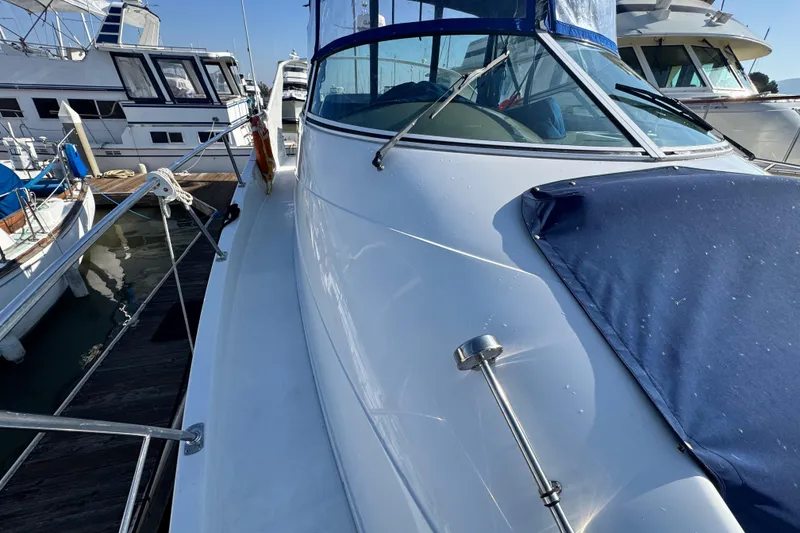 Slide: The Image of 1997 Carver 350 Mariner yacht docked, showcasing sleek design and blue cover. - 22