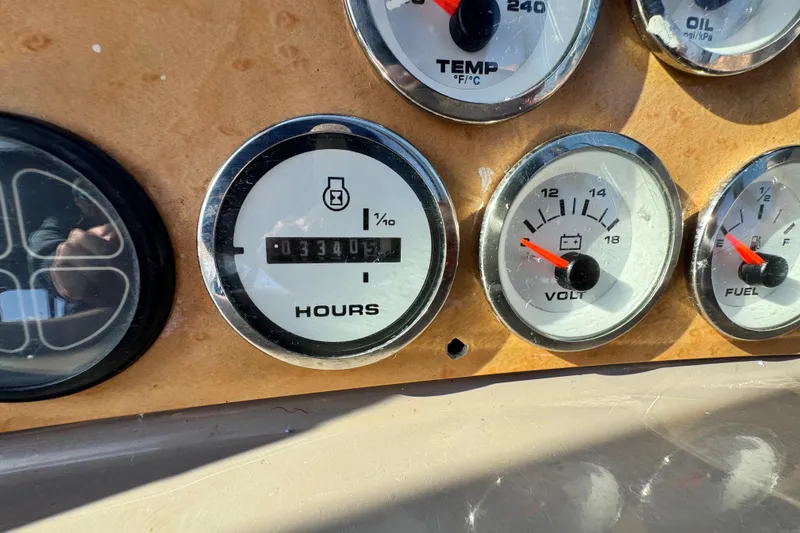 Slide: The Image of Dashboard gauges of a 1997 Carver 350 Mariner boat, showing hours, temperature, voltage, and fuel levels. - 23