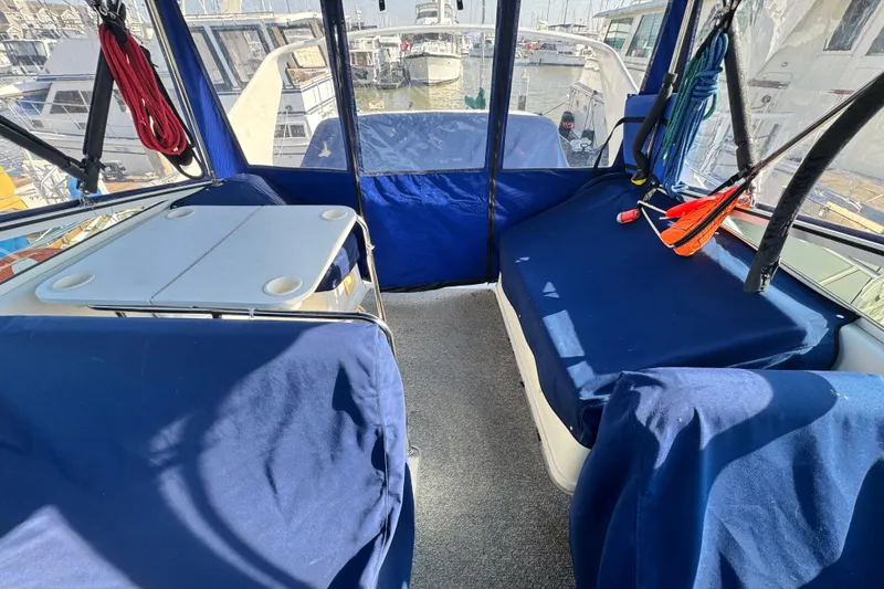 Slide: The Image of 1997 Carver 350 Mariner interior with blue seating and table, docked at marina. - 25