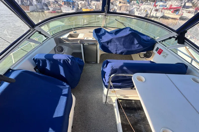 Slide: The Image of 1997 Carver 350 Mariner boat interior with blue covers, docked at marina. - 33
